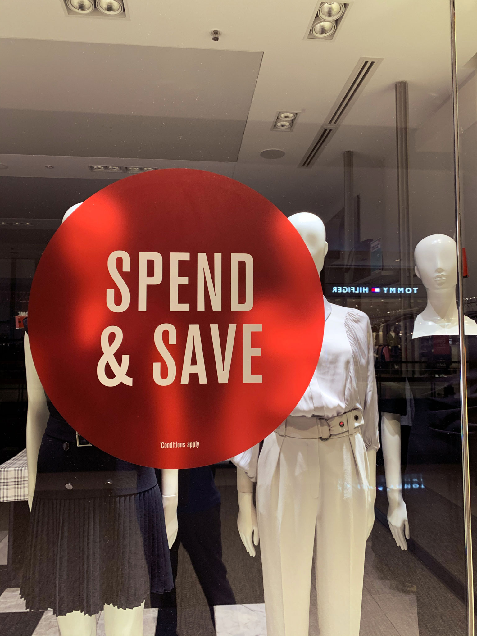 A sign on a clothing store reading "Spend and Save"