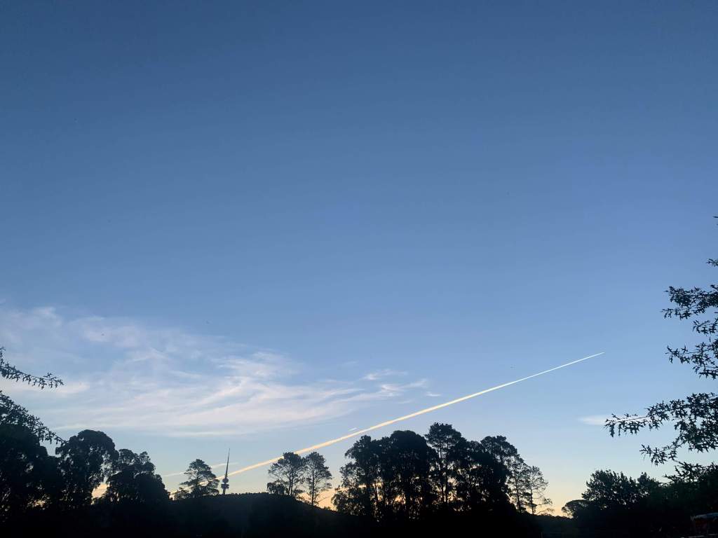 smoke from a jet flying across the sky during sunset, Canberra