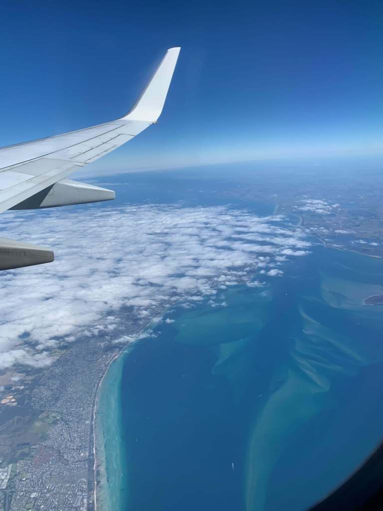 photo of the ocean as seen throug the flight windor