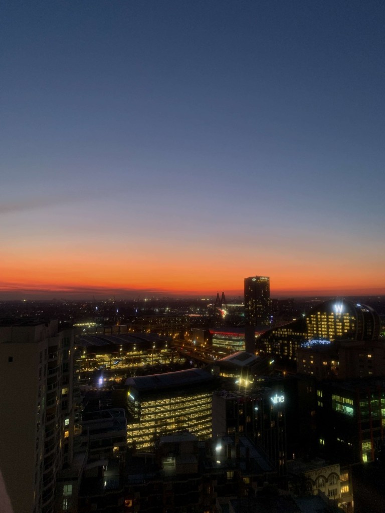 Photo of the sun setting in the horizon, as seen from the 35th floor of a hotel room in Sydney’s CBD. 