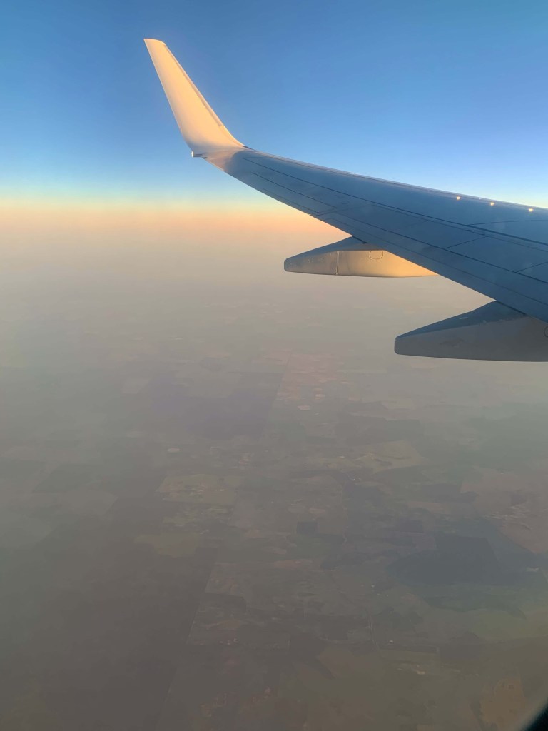 Photo of the sun set shades, as seen from inside an airplane flying above the clouds. 