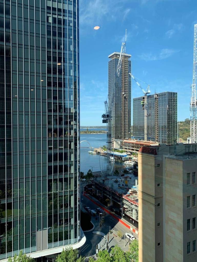Photo of multiple high-storey buildings as seen from the top floor of another high-storey building.