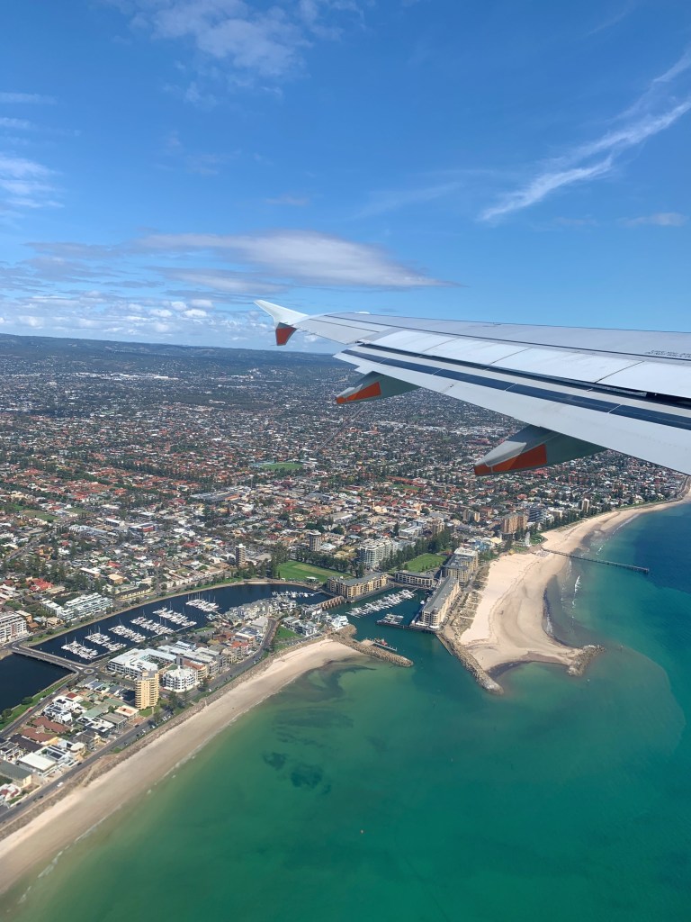 Photo of the Adelaide coastline and jetty as seen from a plane window, during take off. 