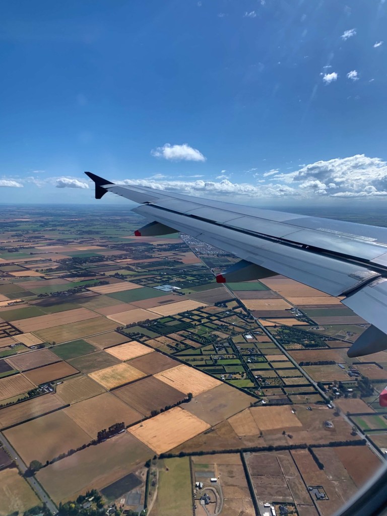 Photo of the city of Christchurch, as seen from the window seat of a plane, as the plane was coming into land. The big rectangular plots on the ground clearly visible from the plane. 