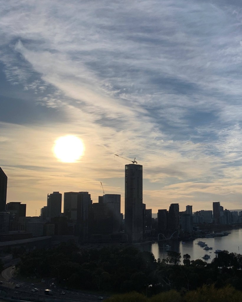 Photo of the sun, just after sunrise with the cranes from two construction sites turned towards east, at the sun.