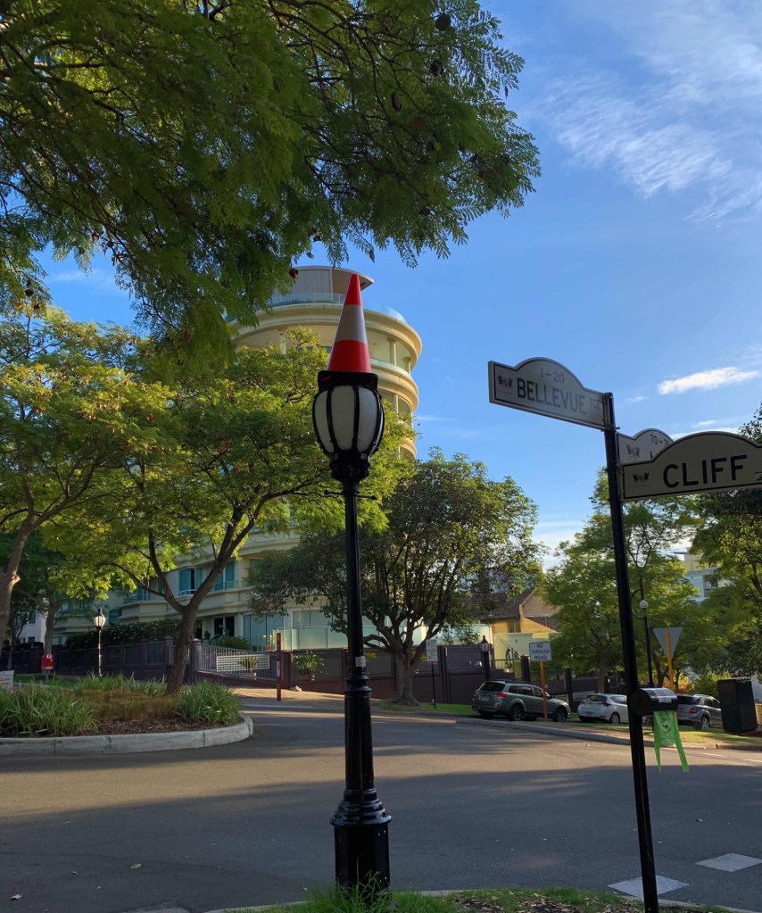 Photo of a street light with a as witch’s hat on it.