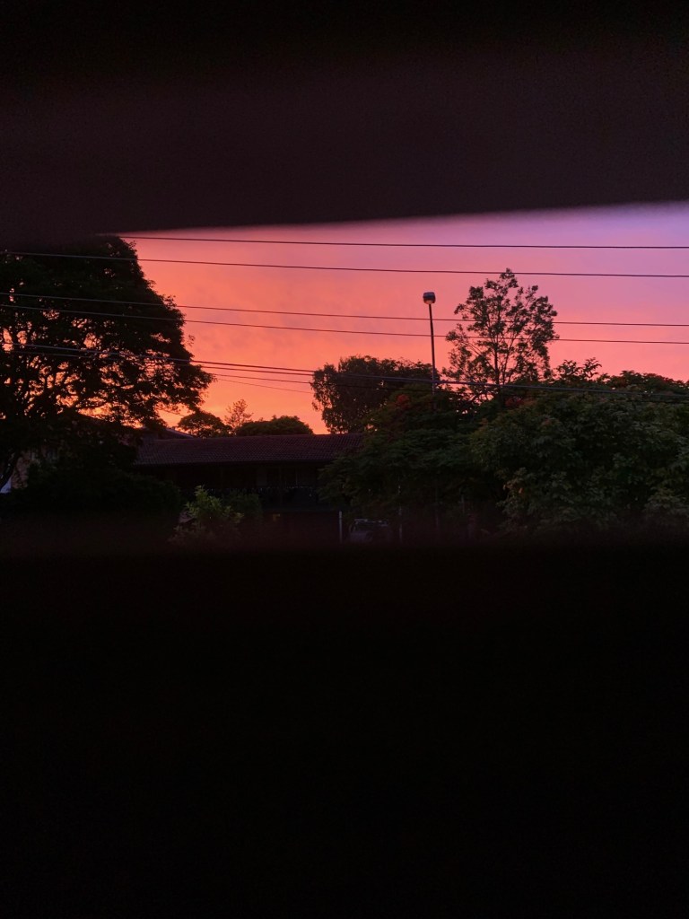 Photo of the sunset as seen through a window. 