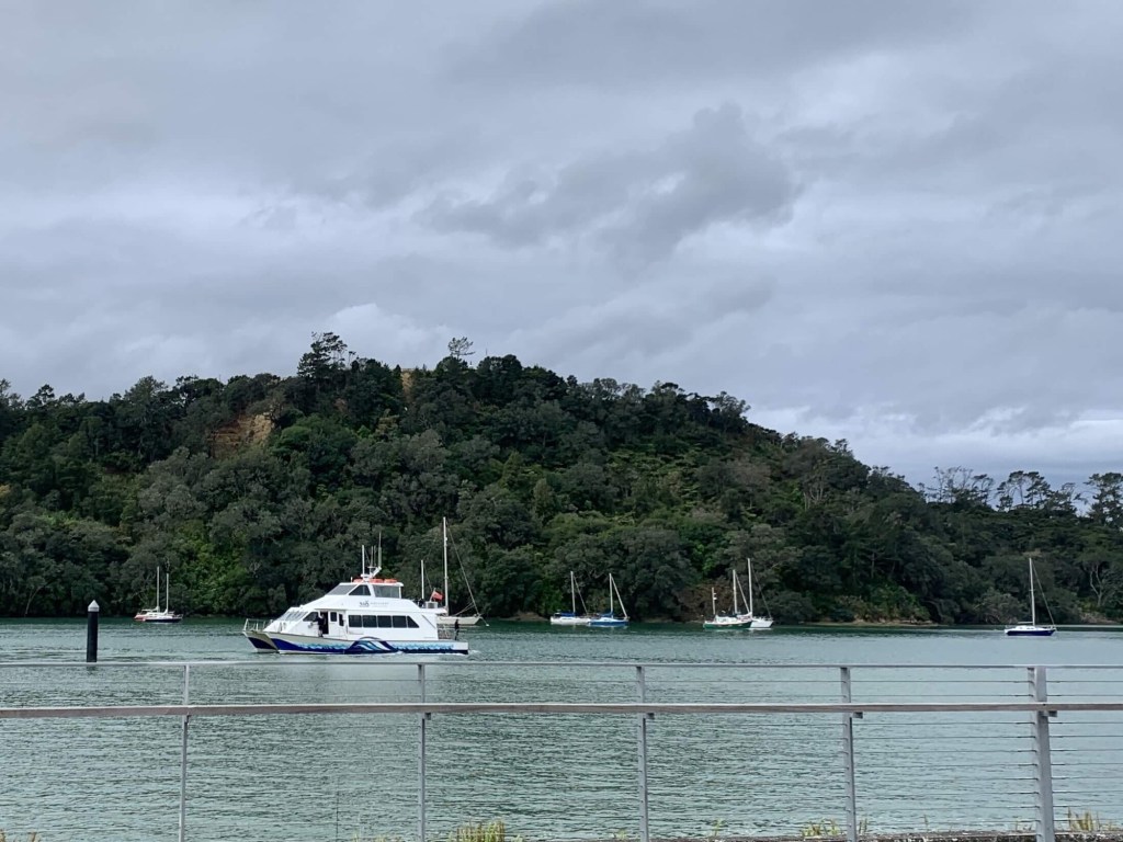 Photo of an Auckland ferry approaching the dock, with other smaller boats in the background. 