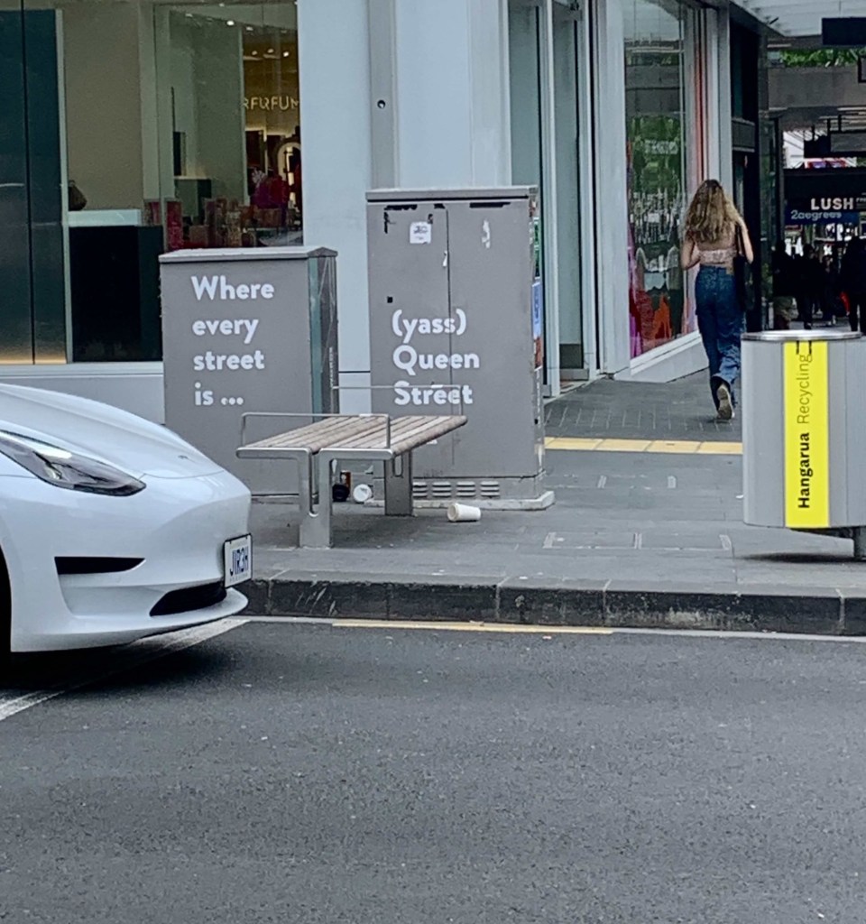 Photo of the electrical circuit box on the street with the words, “Where every stress is… (yaas) Queen Street” painted on it. 