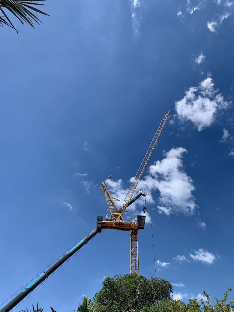 photo of a crane against a vibrant blue sky and scattered white clouds