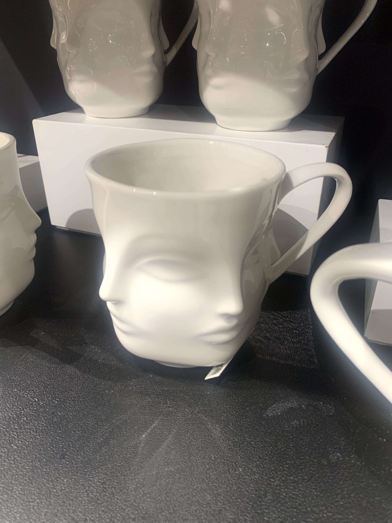 Photo of a mug with two faces looking at either side of 