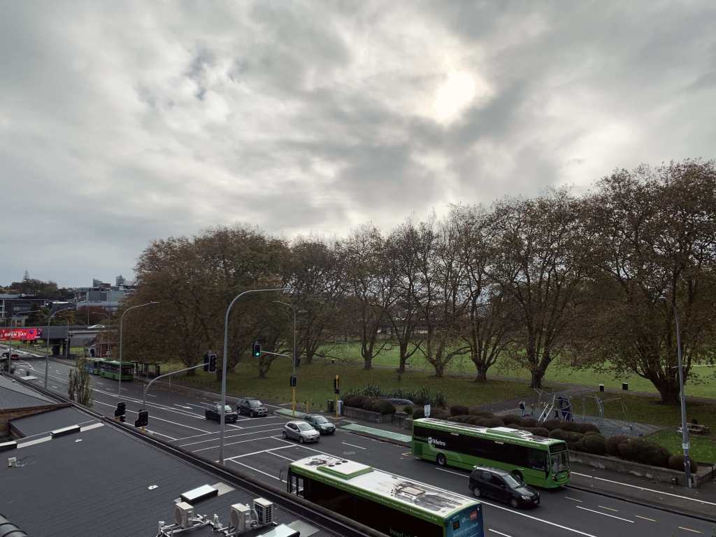 photo of a main road in Auckland city on a cloudy Sunday morning, with two buses and very little traffic on the road